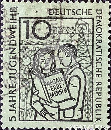Boy and girl with the book â€œWeltall, Erde, Menschâ€, symbolic Editorial Stock Photo